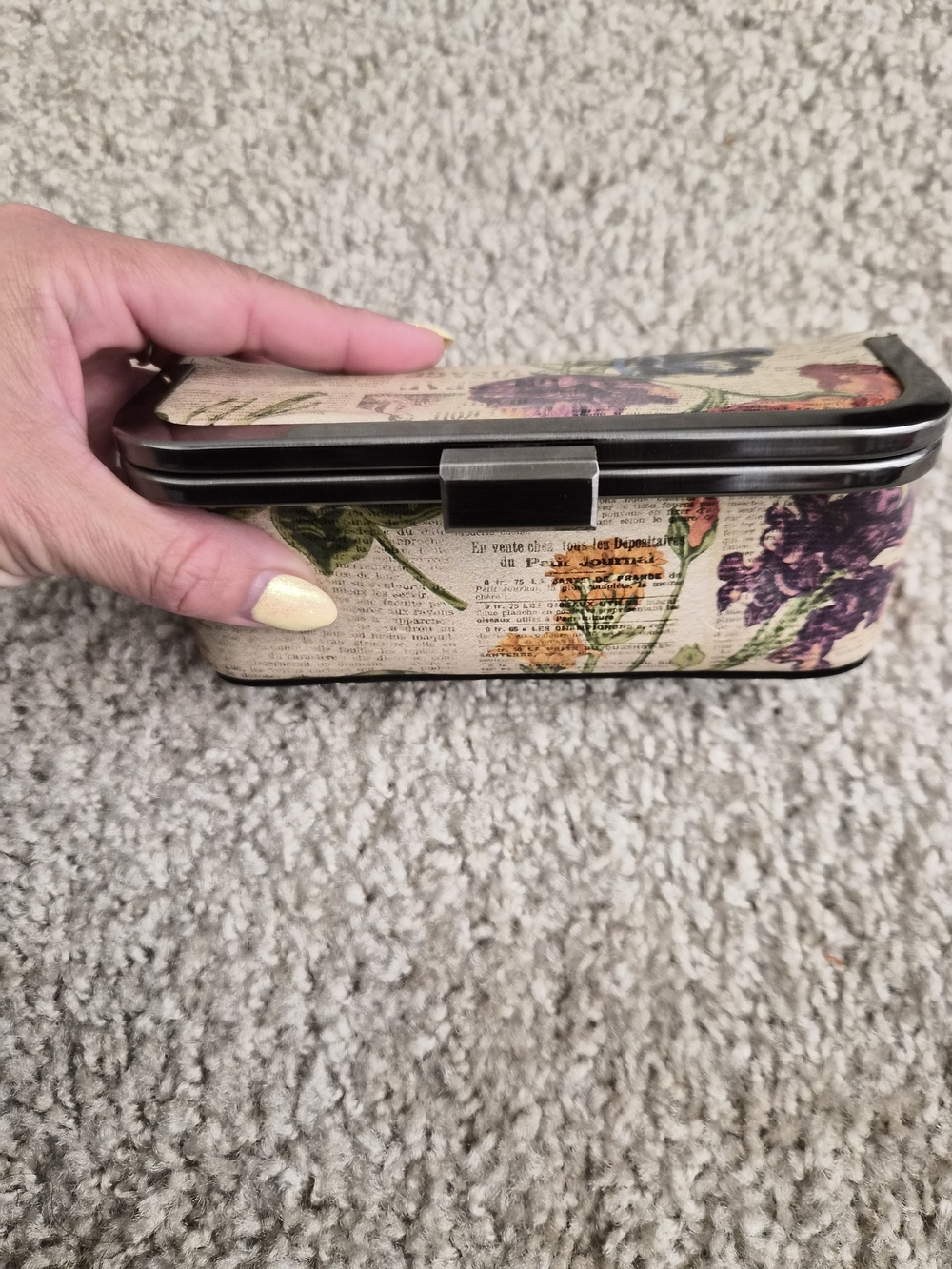 This is a Patricia Nash kiss-lock frame clutch with a built-in mirror